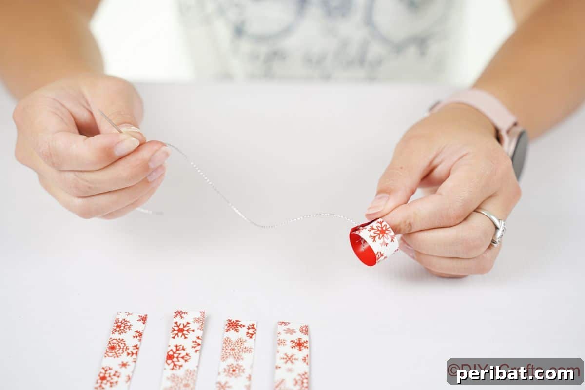 Layered Rolled Paper Christmas Charm 12 hand holding silver thread at end of needle by small circle of paper