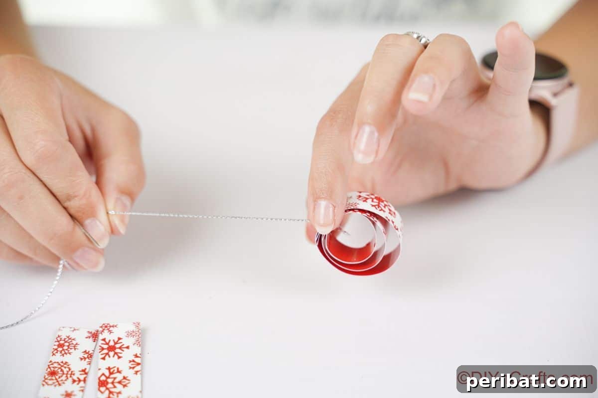 Layered Rolled Paper Christmas Charm 13 Hand pulling silver thread through rounds of white paper