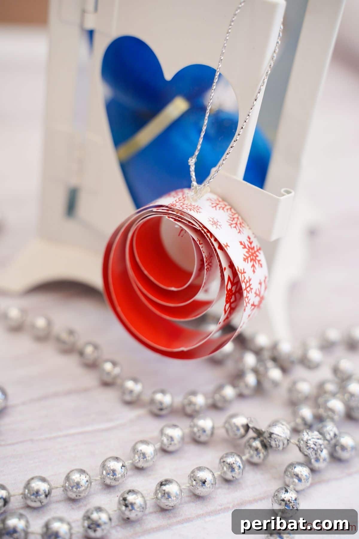 Layered Rolled Paper Christmas Charm 4 red and white round paper ornament on white table by blue ornament
