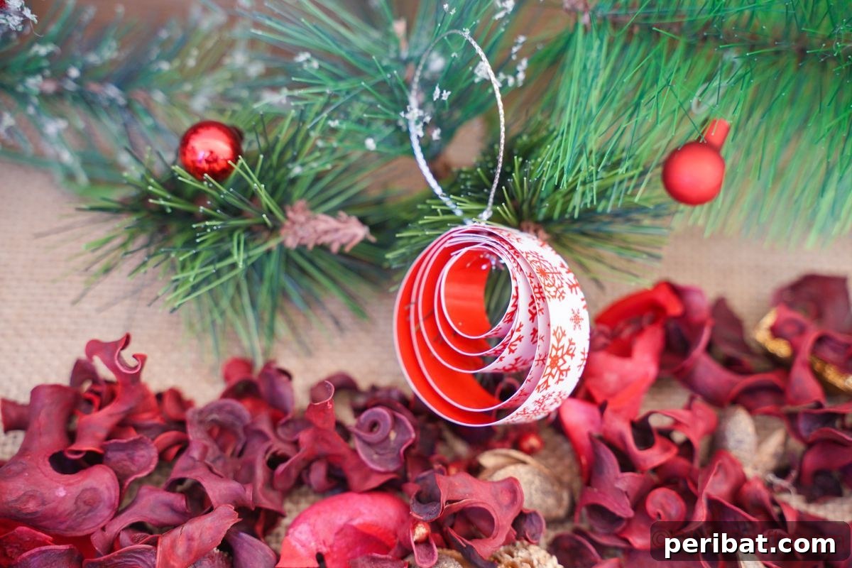 Layered Rolled Paper Christmas Charm 7 paper ornament with red and white theme hanging on green branch by potpourri