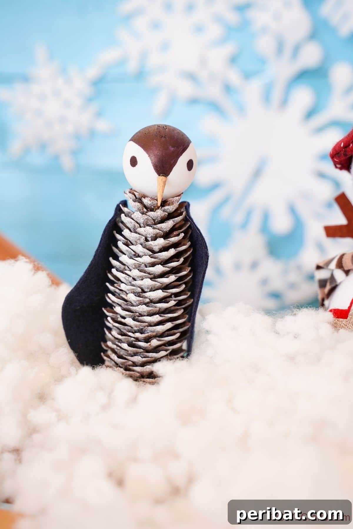 Winter Pinecone Penguin Fun 2 Adorable miniature pinecone penguin sitting on a bed of fake snow, ready to add charm to any festive display.