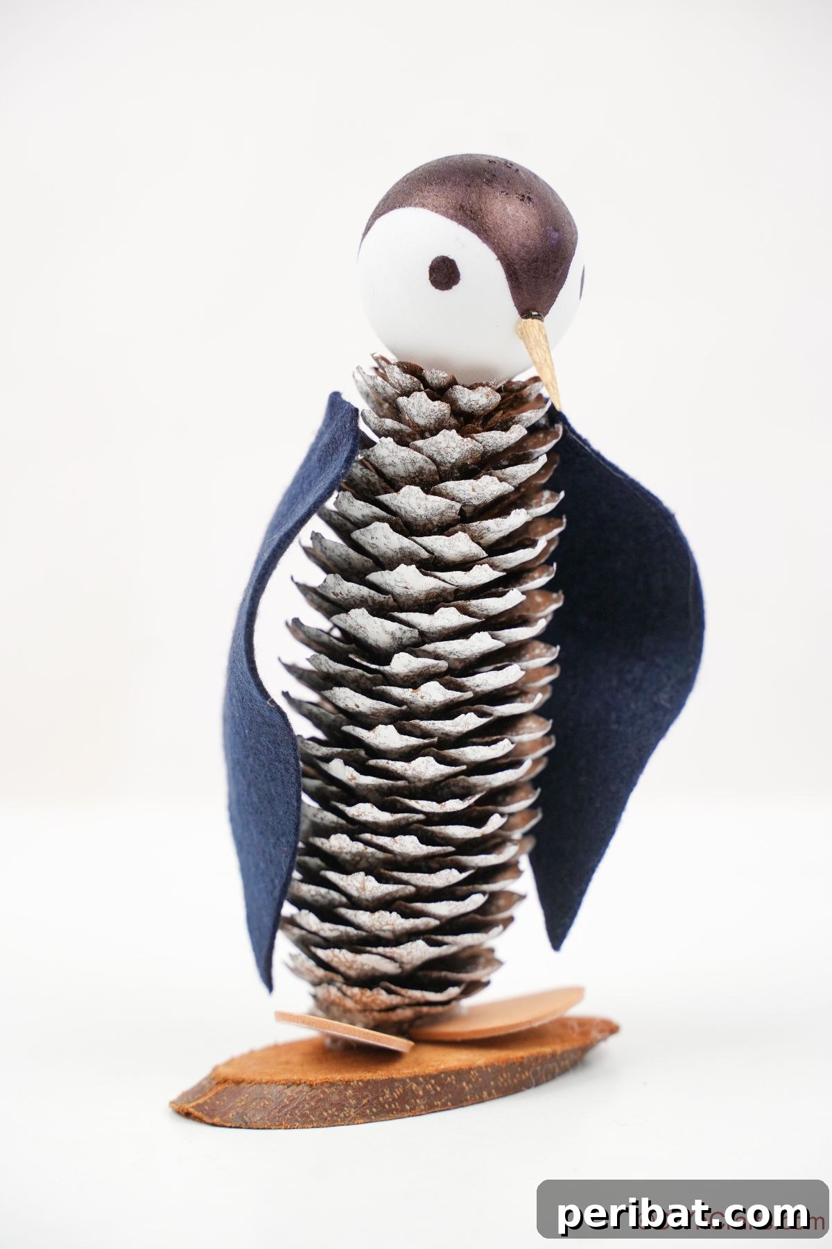 Winter Pinecone Penguin Fun 27 A solitary pinecone penguin sitting elegantly on a clean white background, highlighting its simple, rustic beauty and craftsmanship.