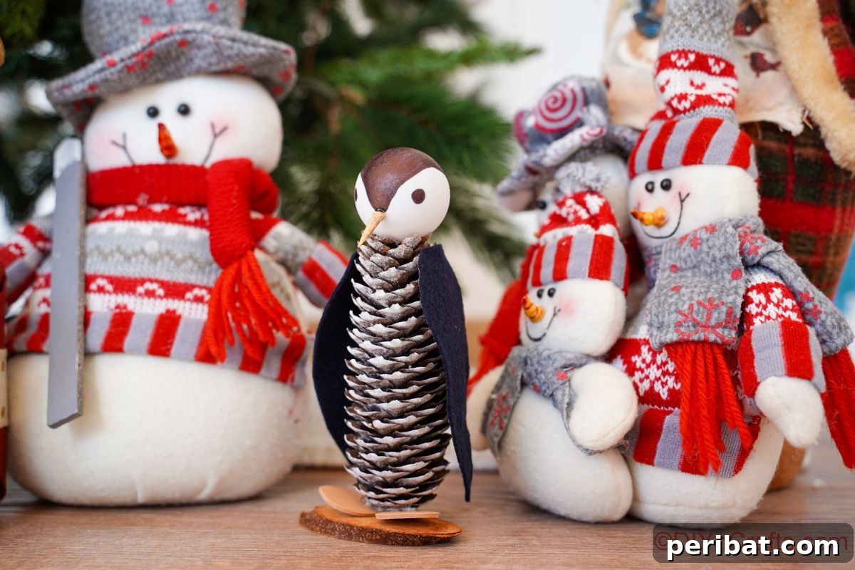 Winter Pinecone Penguin Fun 5 A charming pinecone penguin resting on a table alongside a handmade sock snowman, creating a cozy winter vignette.