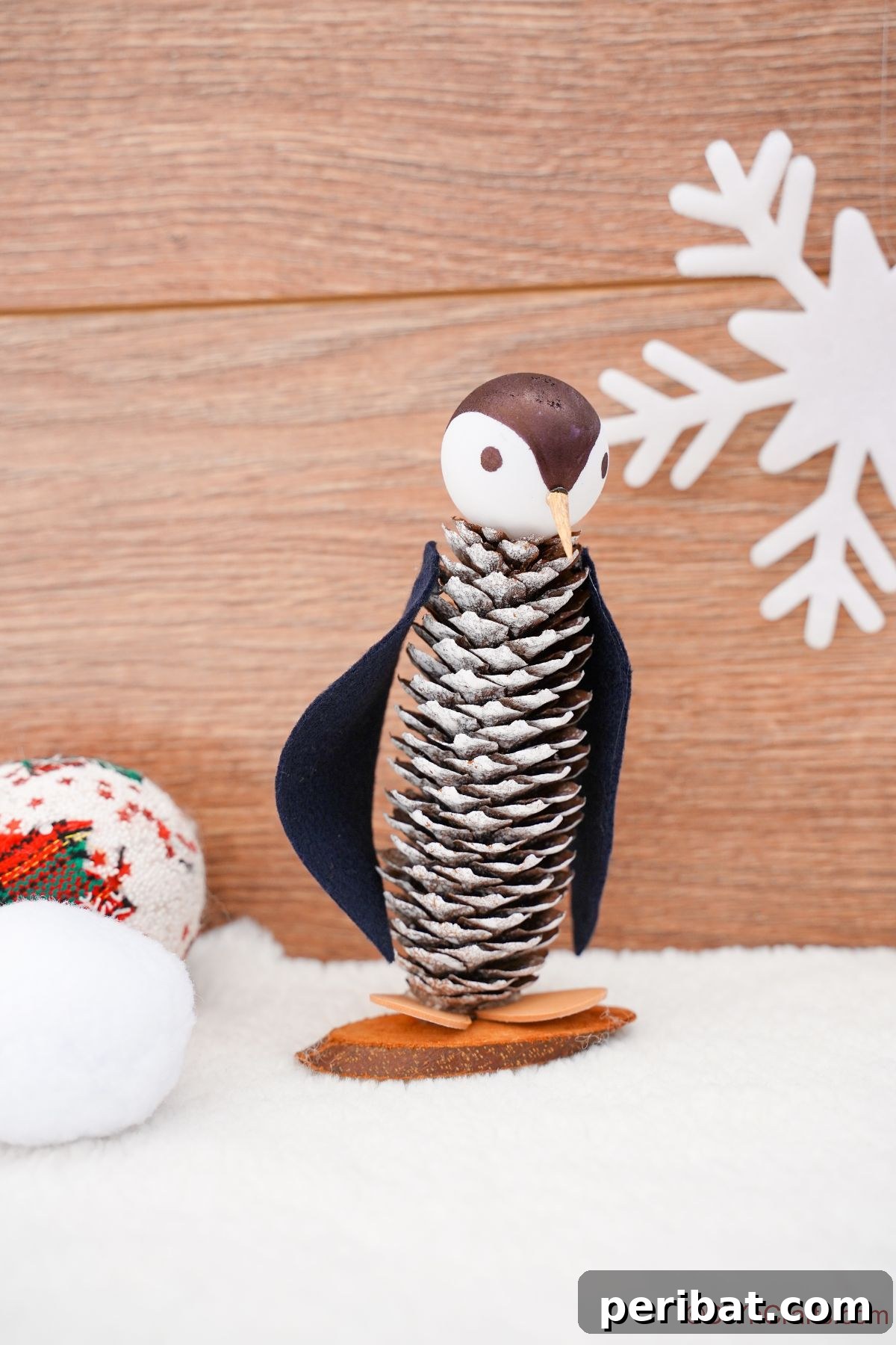 Winter Pinecone Penguin Fun 6 A rustic pinecone penguin with white-tipped scales, positioned against a warm wooden background, showcasing its simple beauty.