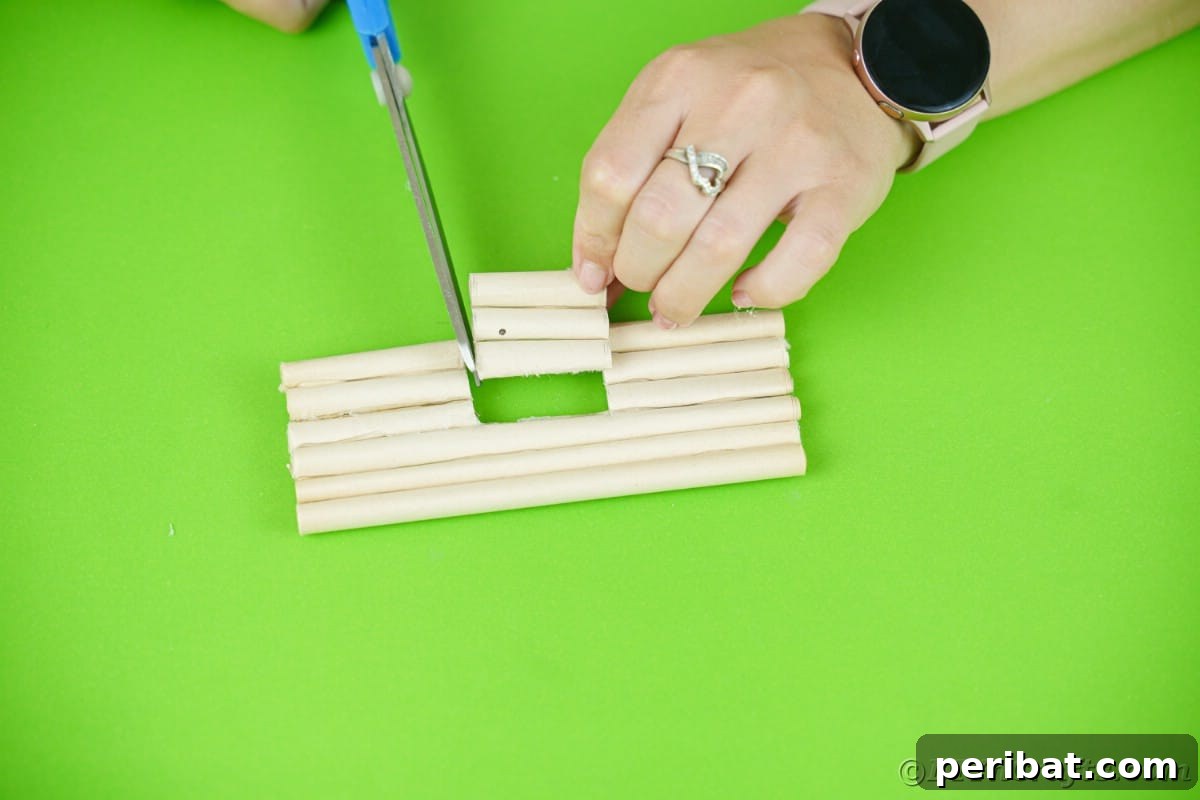 blue scissors being used to cut door out of paper log wall