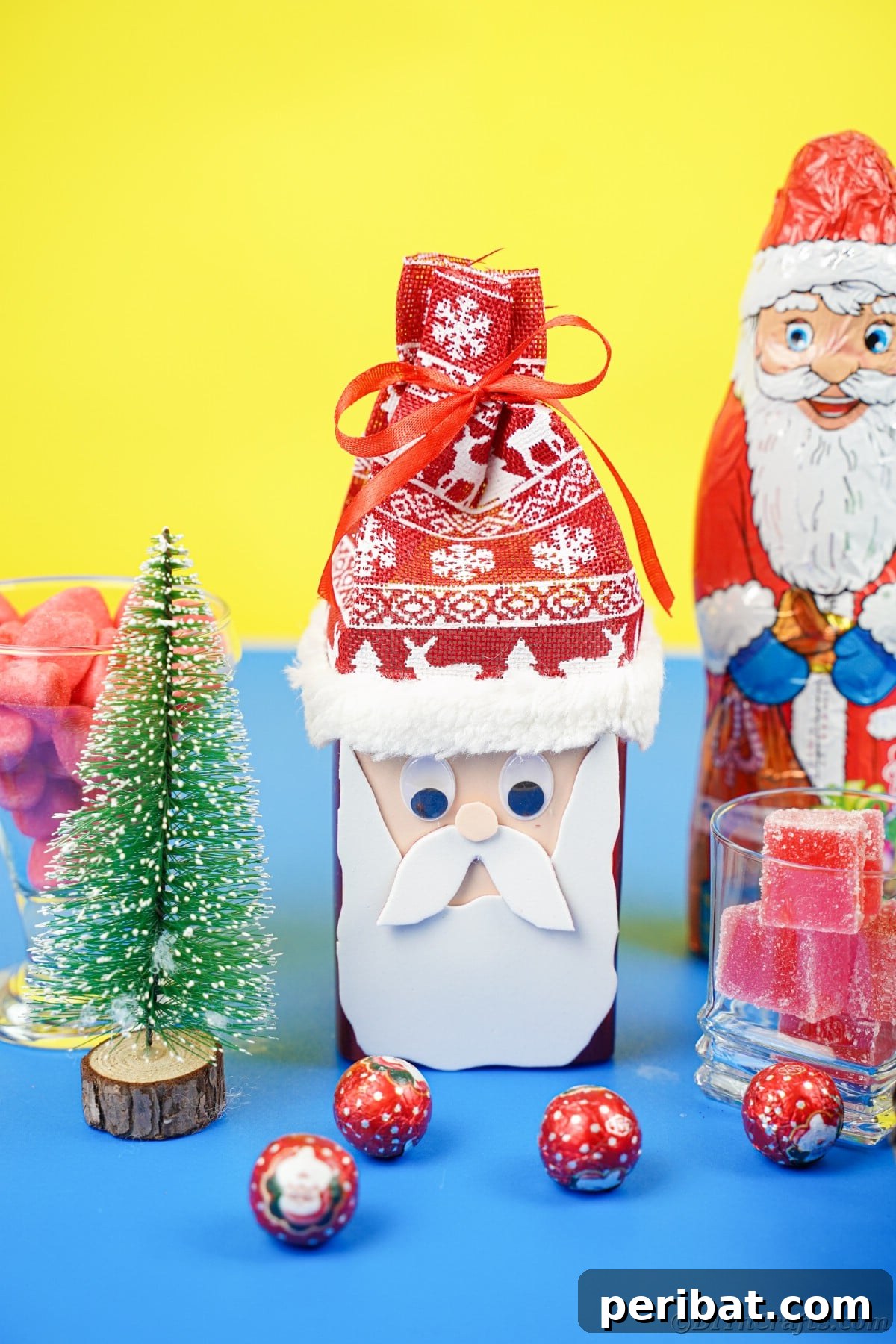 Jolly Upcycled Milk Carton Santa Candy Box 21 Blue and yellow background with a variety of Santa Claus figures and pinecones, depicting a festive display