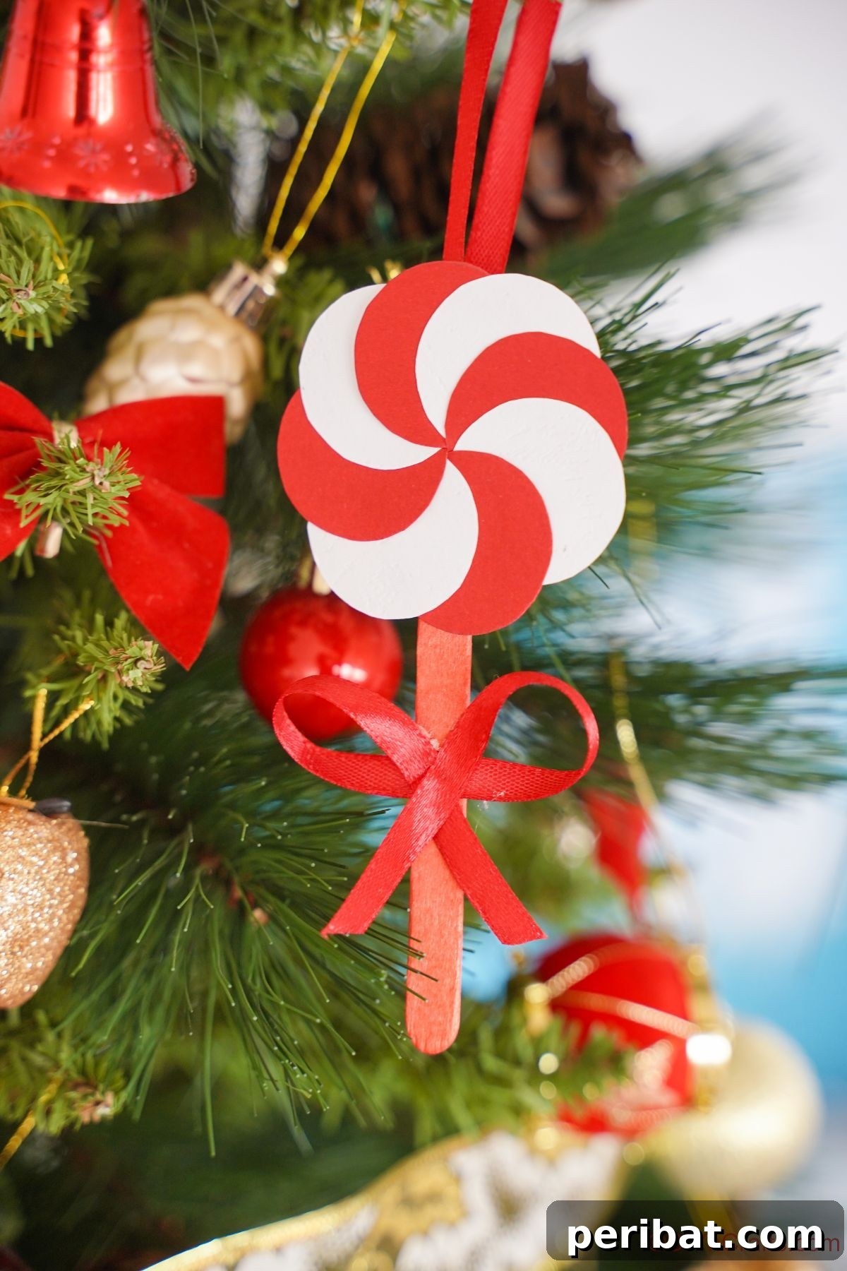 Sweet Peppermint Stick Decor 2 Red and white swirl paper peppermint candy ornament on Christmas tree, perfect for a festive DIY project.