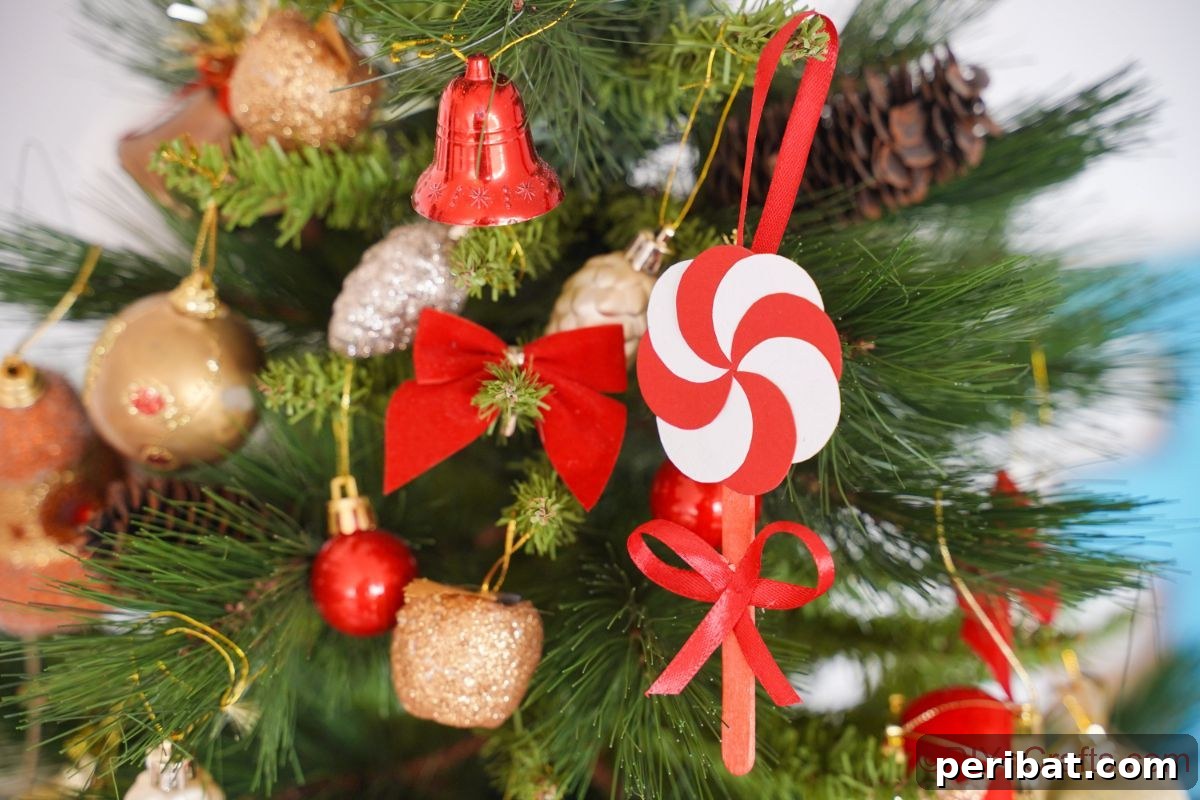 Sweet Peppermint Stick Decor 7 Peppermint candy ornament hanging on a Christmas tree, showcasing a classic holiday decoration.