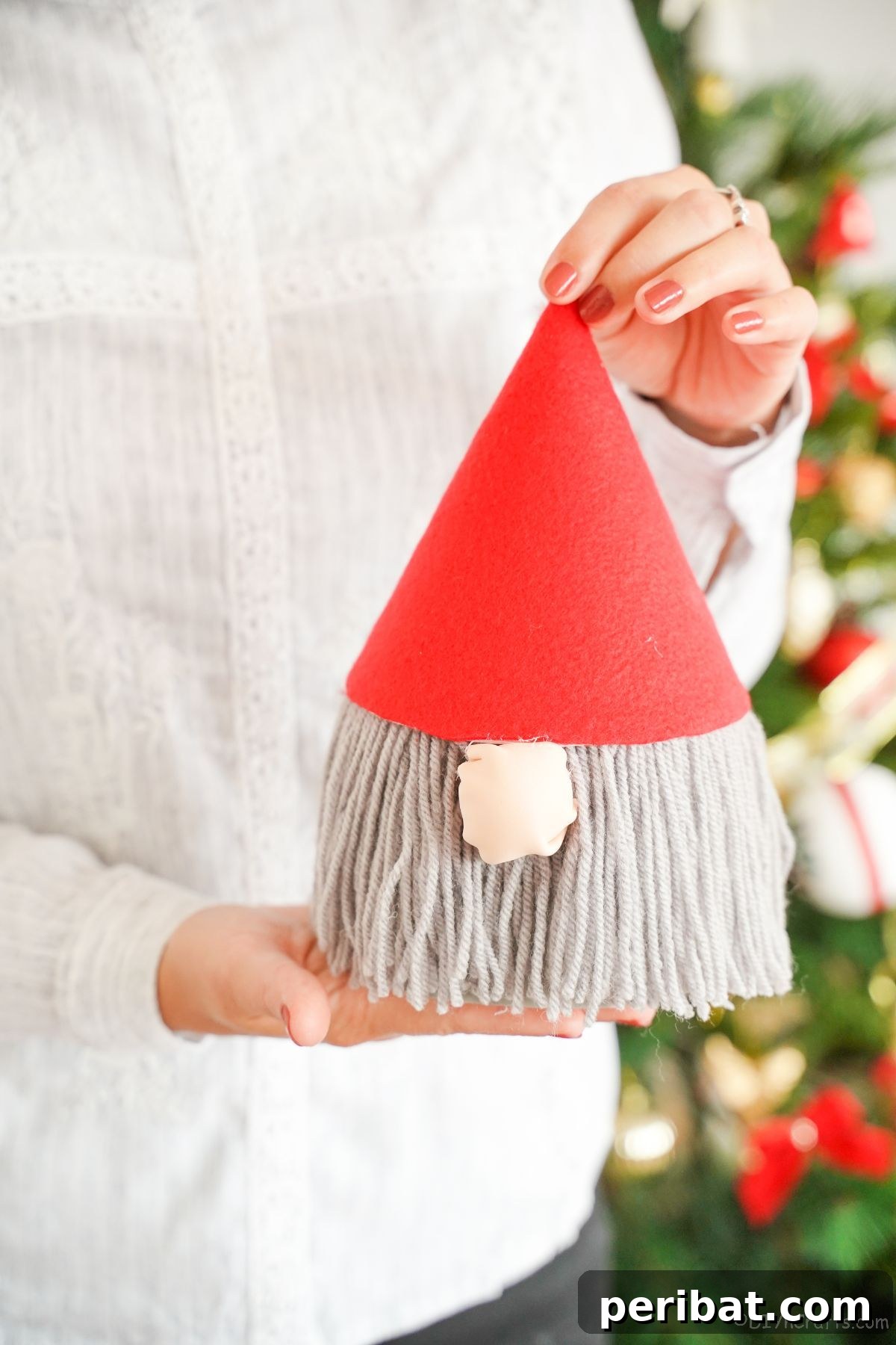 lady holding gnome with red hat
