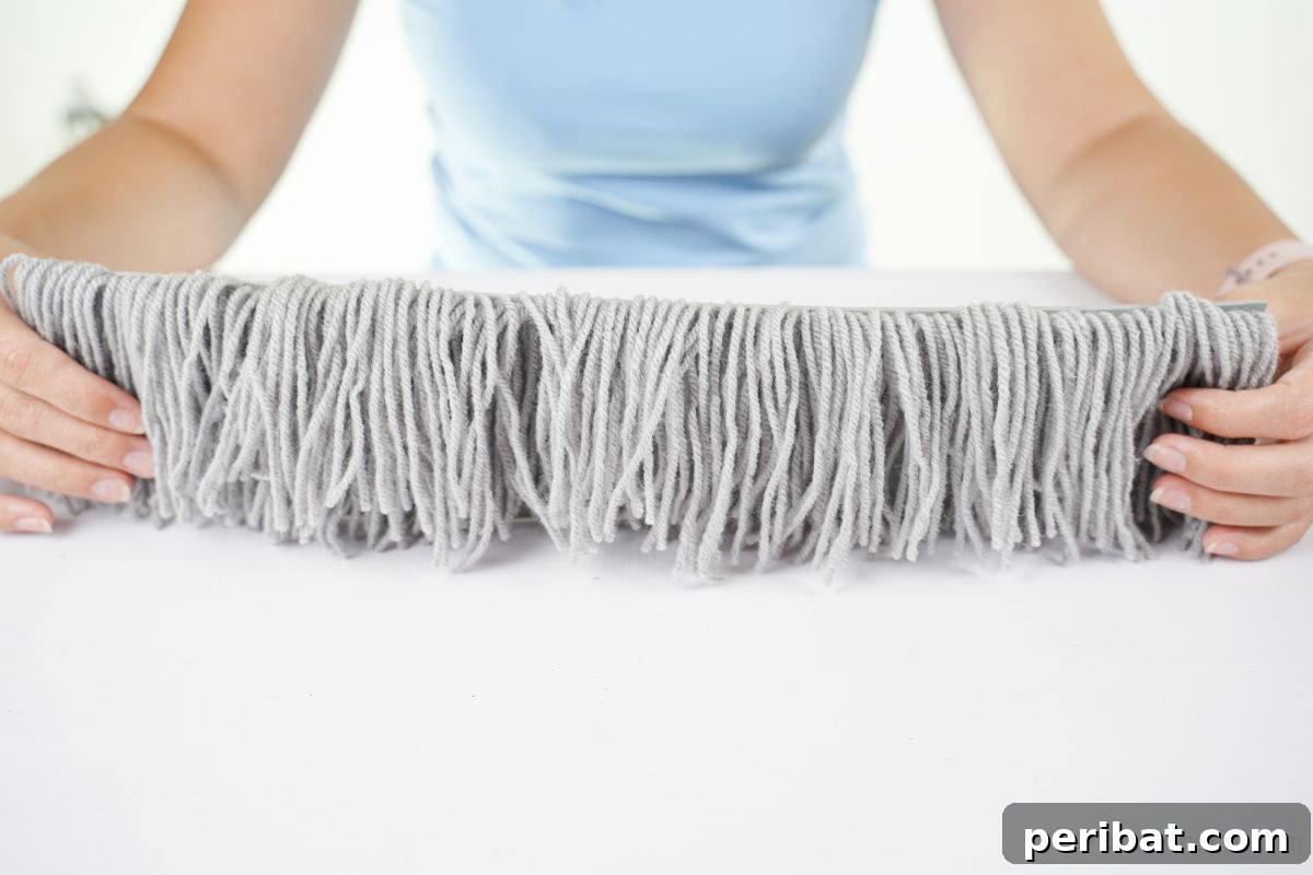 lady holding gray yarn piece on white table