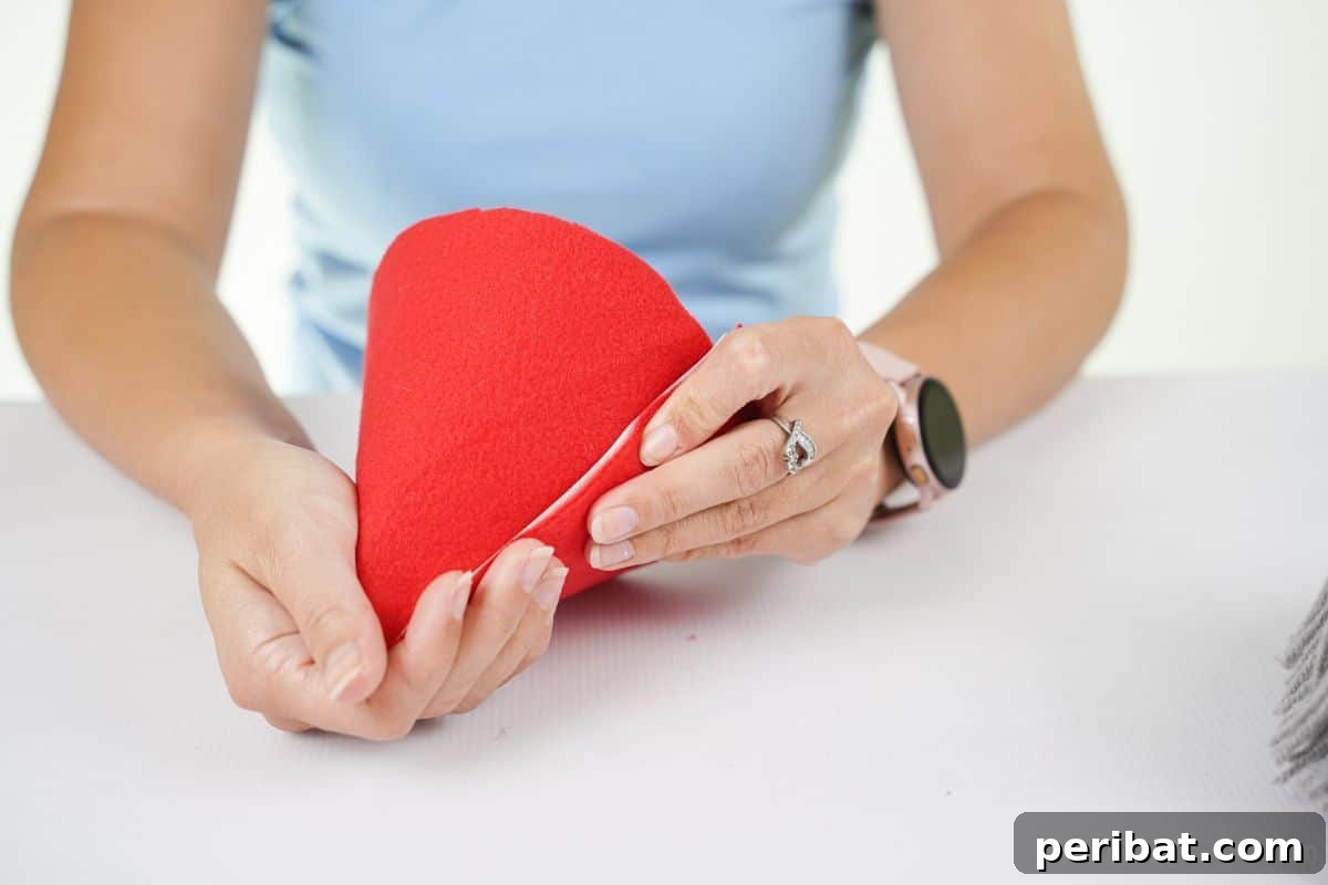 hands rolling red felt into cone hat