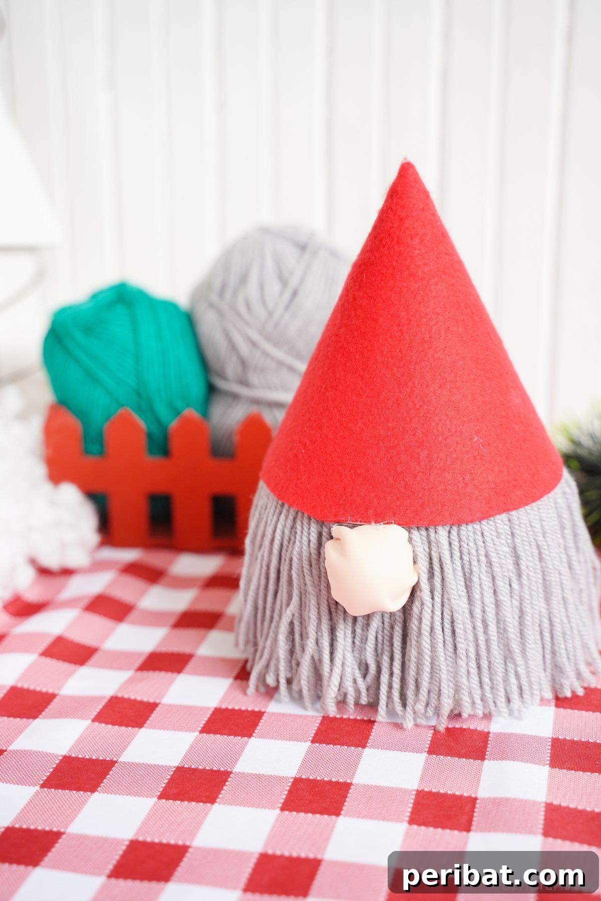 gnome with red hat and gray beard on table with red checked tablecloth