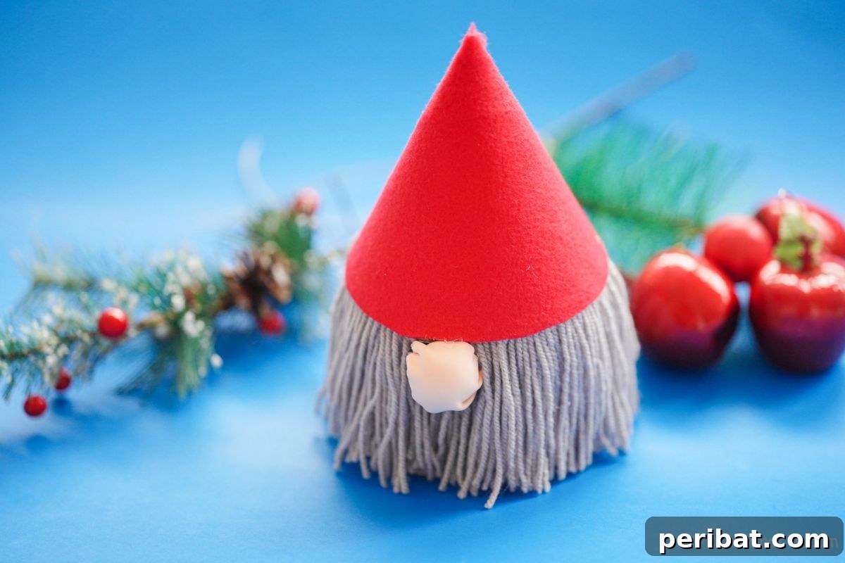 gnome with gray beard on blue table with christmas decorations