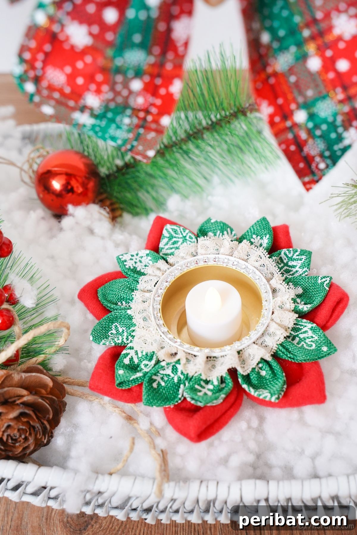 Festive Fabric Floral Candle Centerpiece 6 red and green flower candle holder on fake snow with holiday ribbon in background