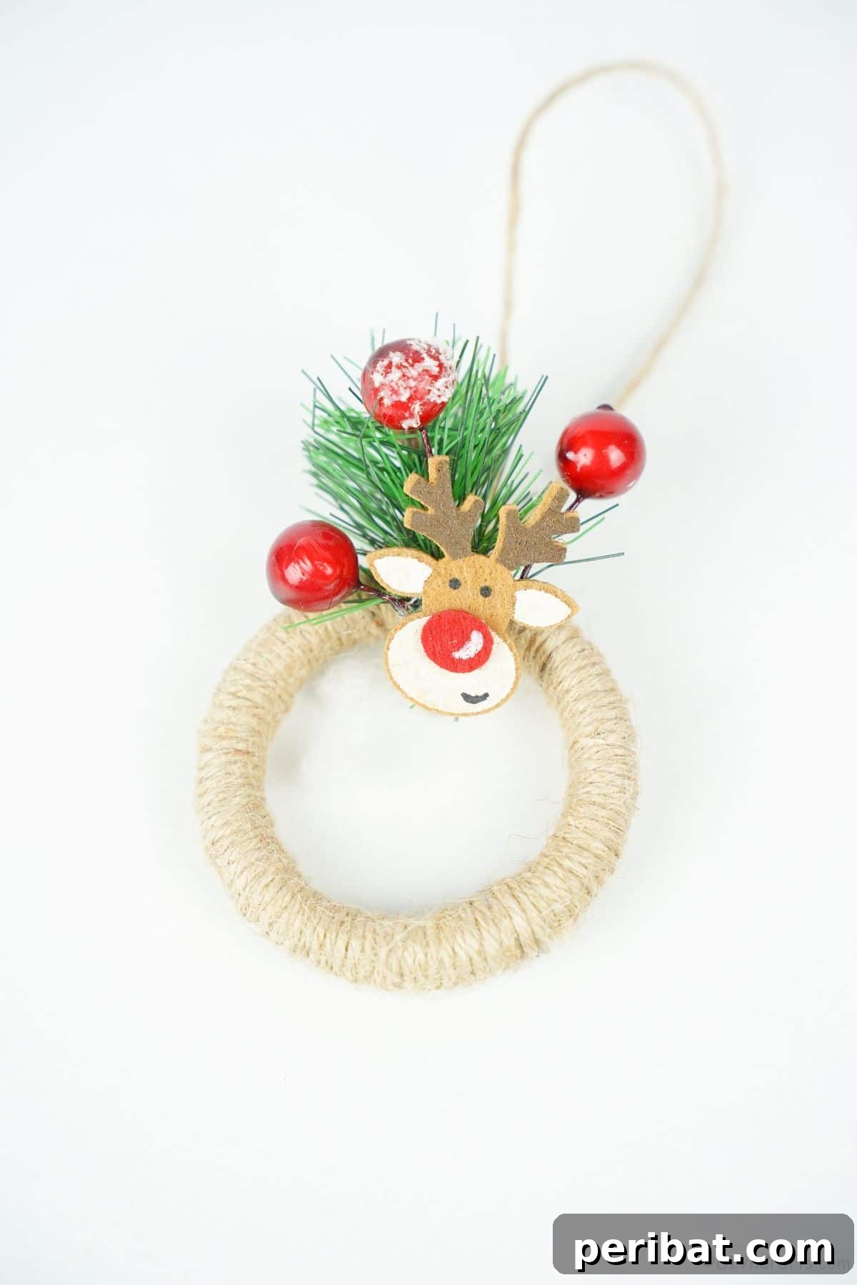 A charming twine-wrapped mini wreath ornament, showcasing its simple yet elegant rustic design, presented on a clean white table.
