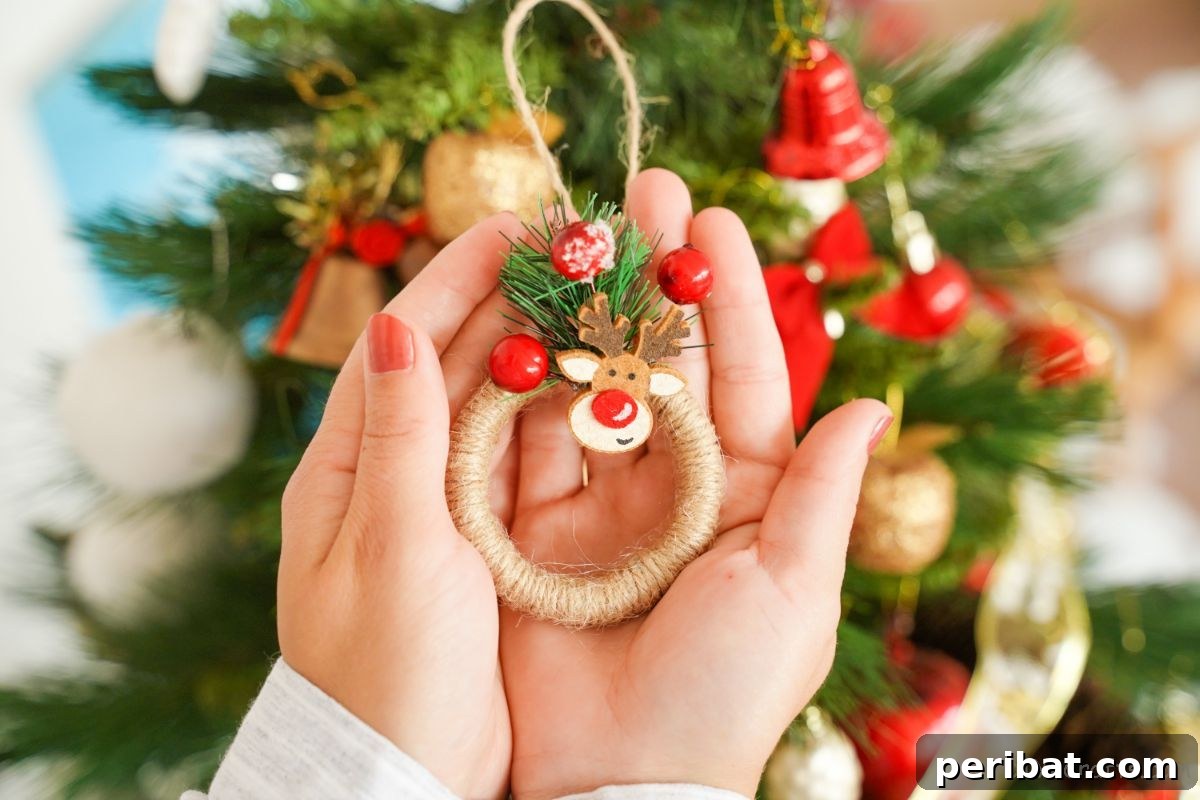 Close-up of hands gently holding a miniature twine-wrapped wreath ornament, highlighting its handmade charm and intricate details.
