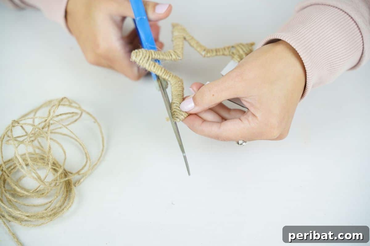 Blue scissors carefully trimming the end of the twine from the wrapped star, ensuring a neat finish.