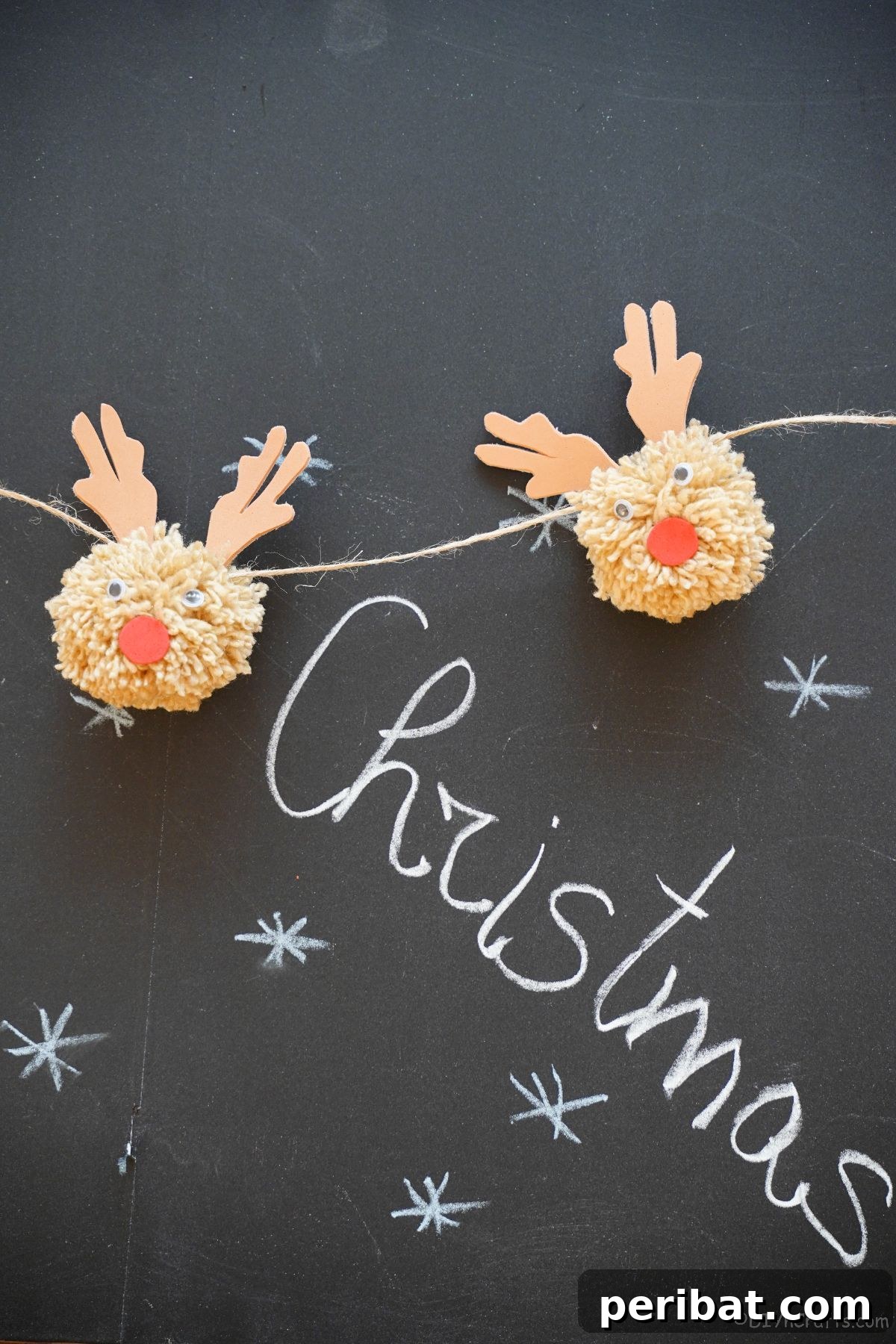 Festive Fluffy Reindeer Christmas Garland Craft 18 Two pom pom reindeer against a chalkboard with the word 'Christmas'