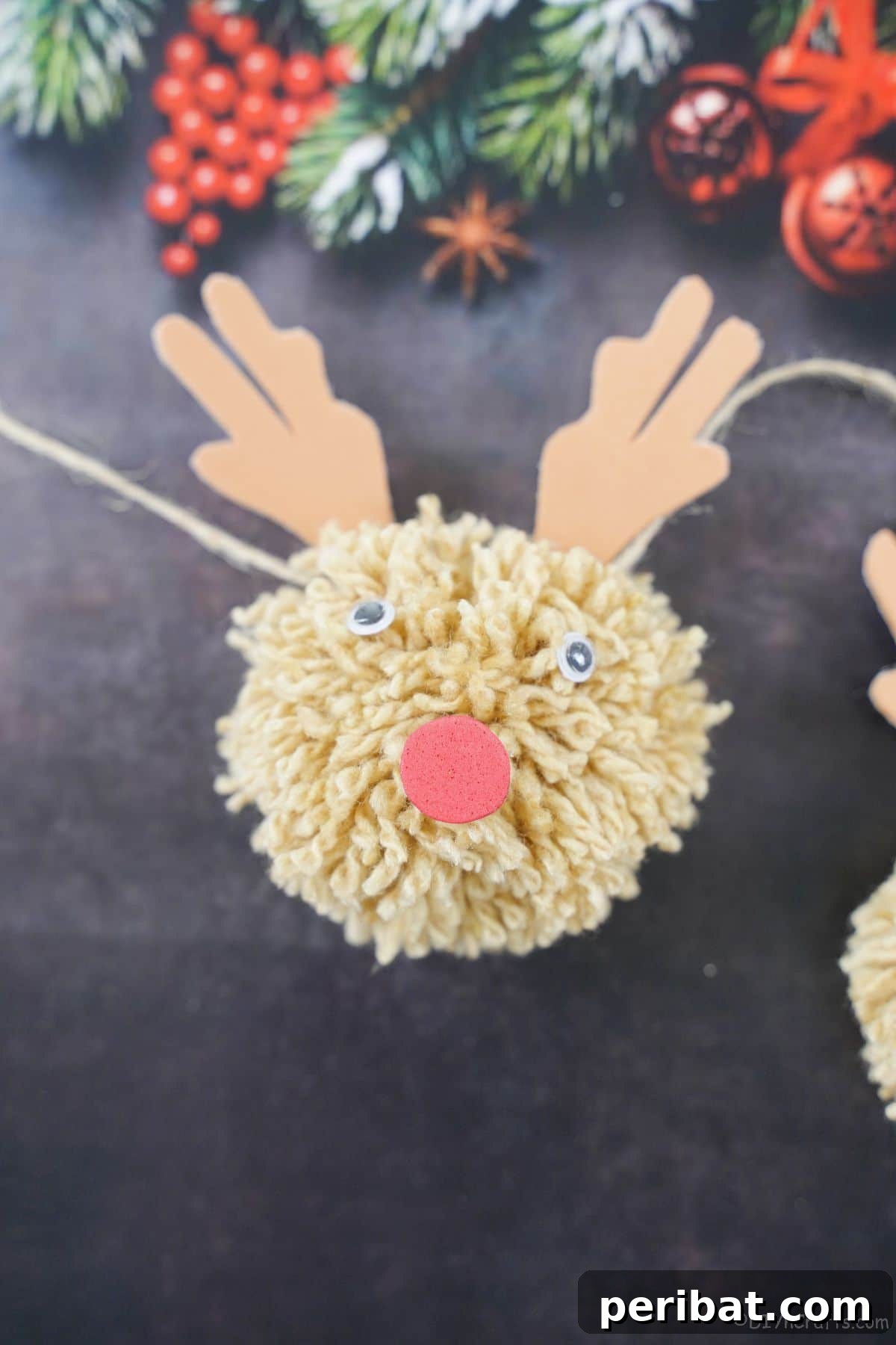 Festive Fluffy Reindeer Christmas Garland Craft 6 A reindeer yarn garland displayed on black paper, highlighting its texture