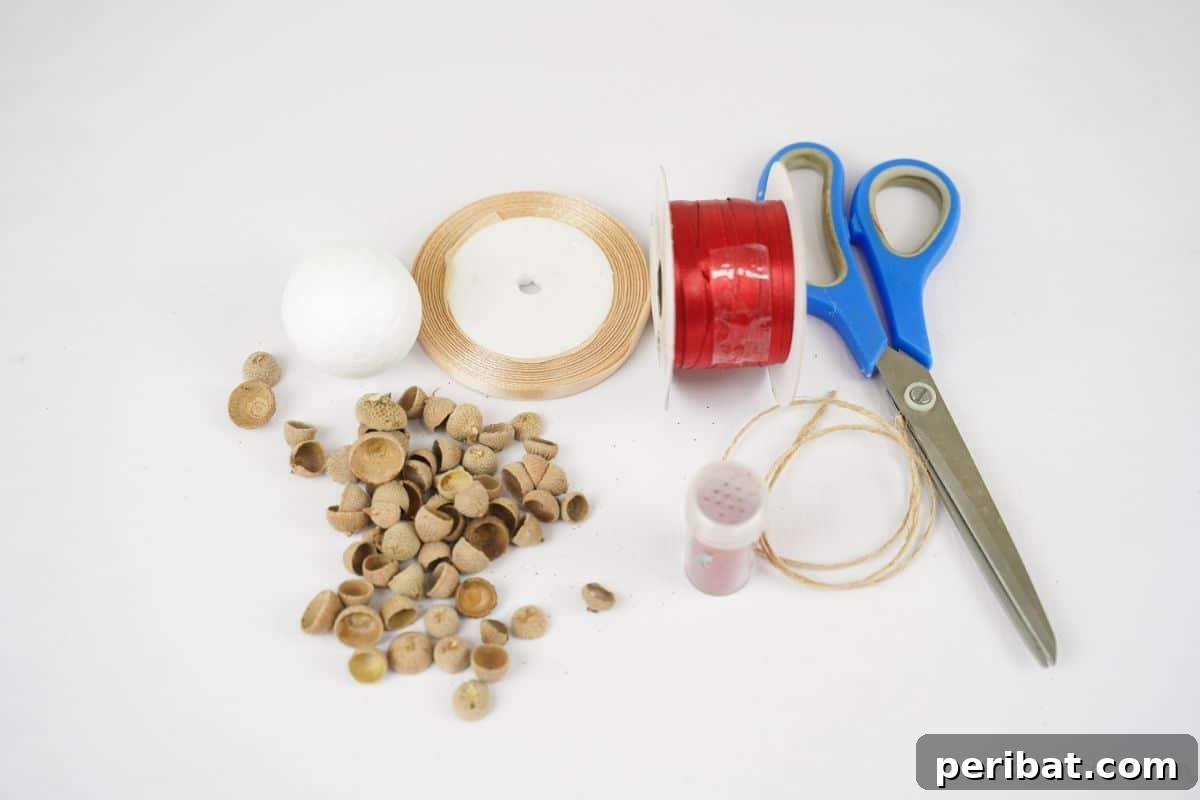 Handcrafted Sparkling Acorn Cap Christmas Ornament 9 A curated display of craft materials for the acorn cap ornament including twine, clean acorn caps, and scissors, arranged neatly on a white table.