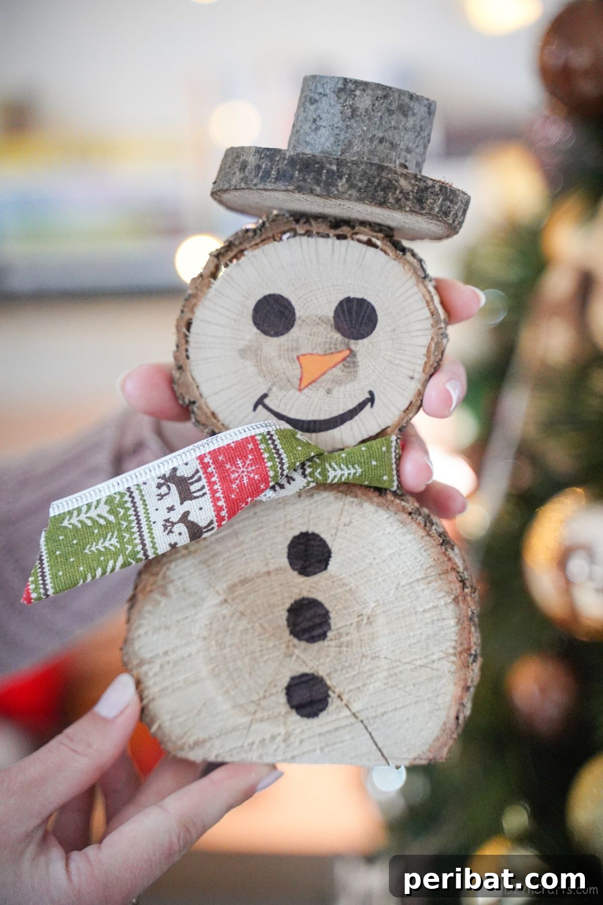 Charming Wood Slice Snowman Winter Display 2 Rustic wood slice snowman with a green and red plaid ribbon scarf, sitting on a wooden surface.