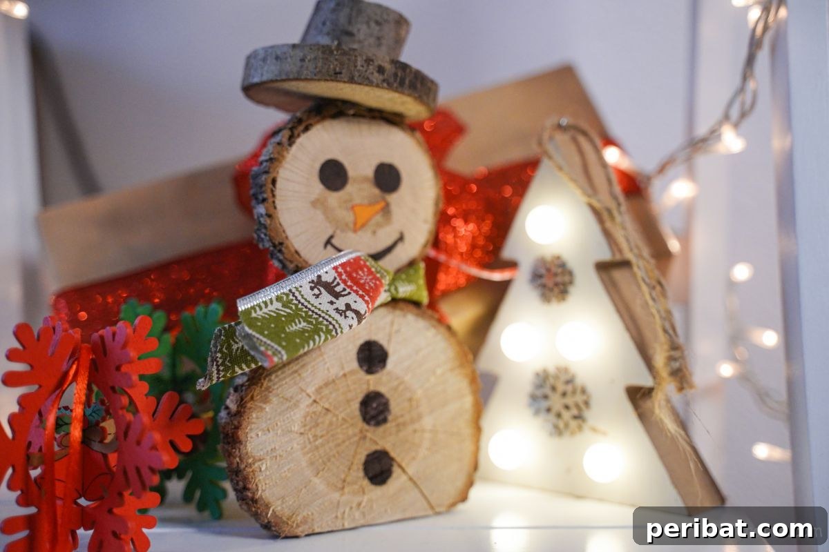Charming Wood Slice Snowman Winter Display 16 A completed wood slice snowman, adorned with a hat and scarf, ready for display on a table.