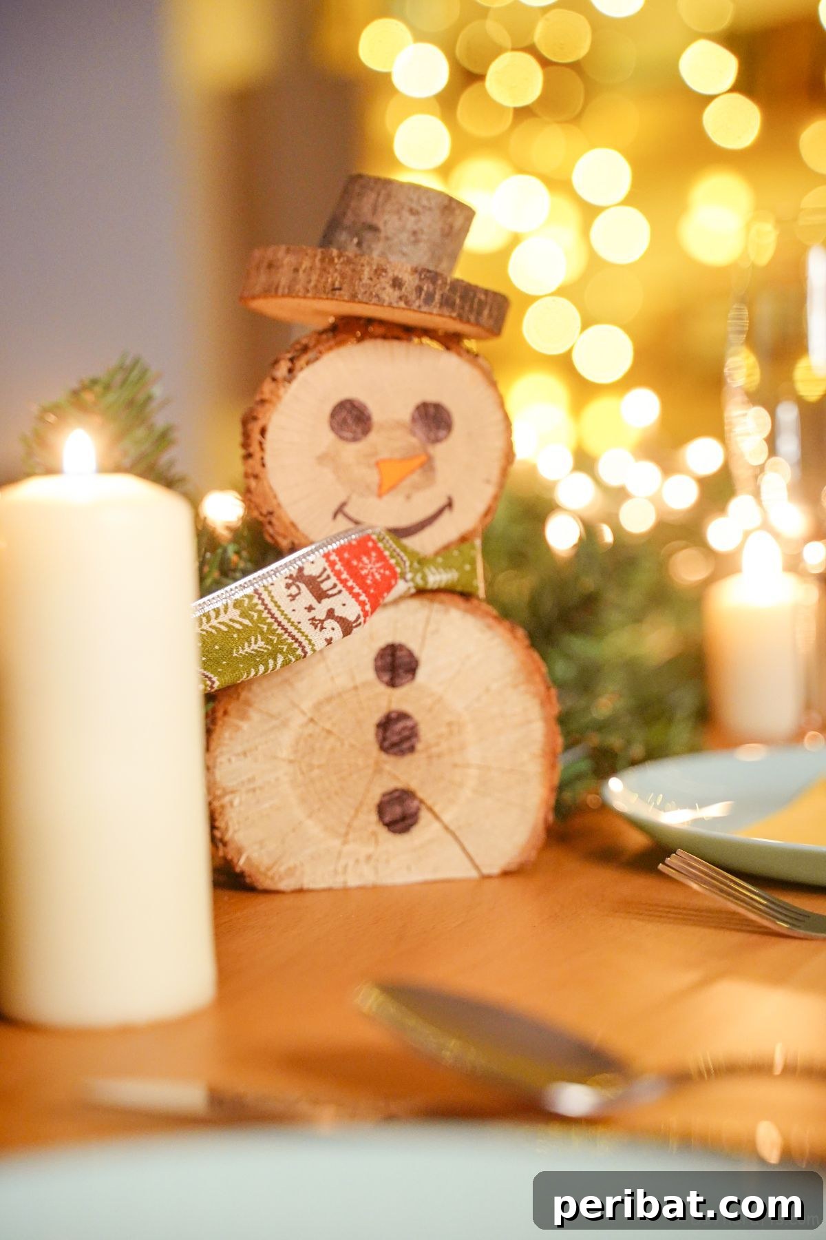 Charming Wood Slice Snowman Winter Display 18 A festive holiday place setting featuring a white candle, evergreen sprigs, and a small wood slice snowman with a red and white checkered scarf, creating a cozy and rustic ambiance.