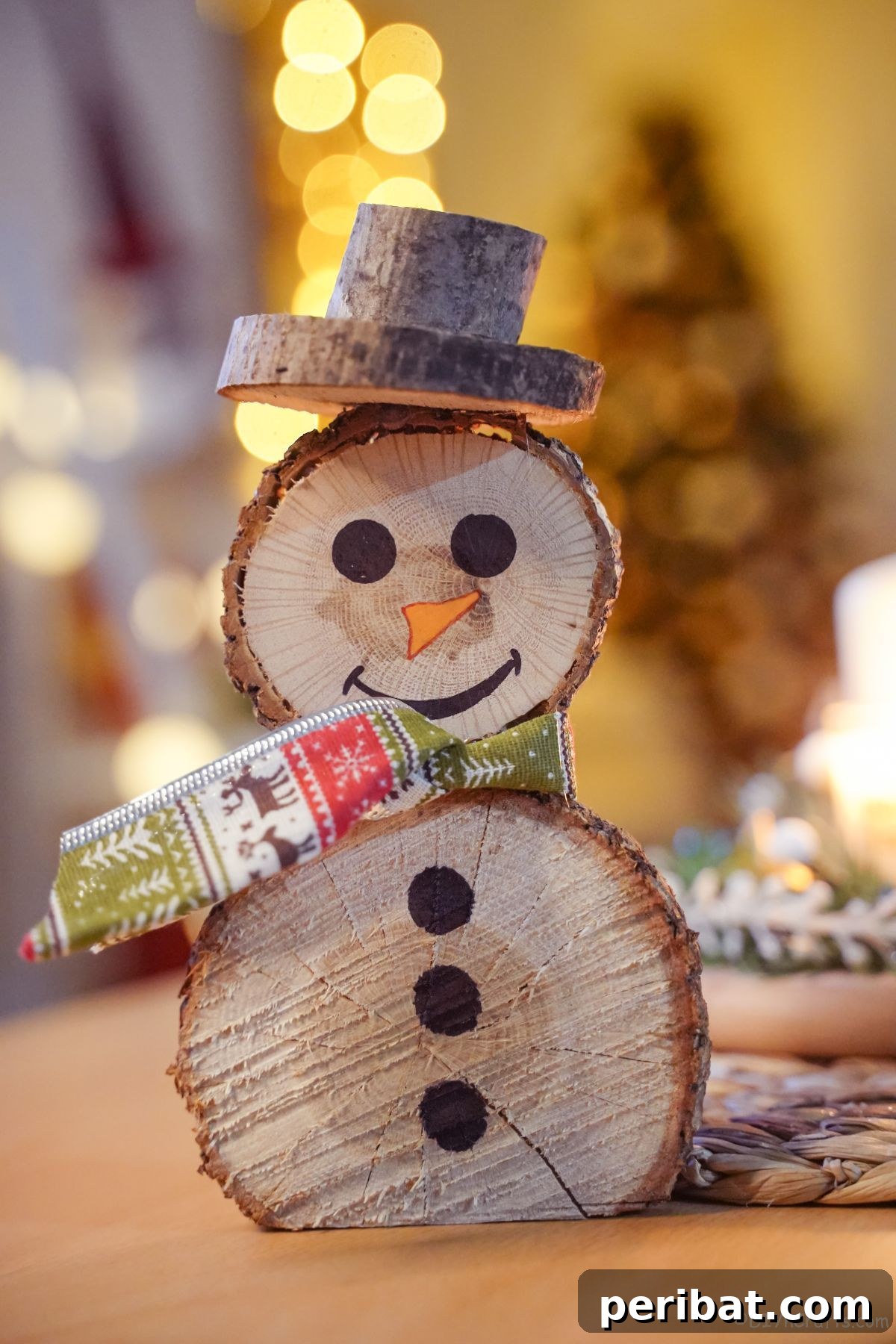 Charming Wood Slice Snowman Winter Display 7 A beautifully crafted wood slice snowman with a festive green and white patterned scarf, resting on a rustic wooden table.