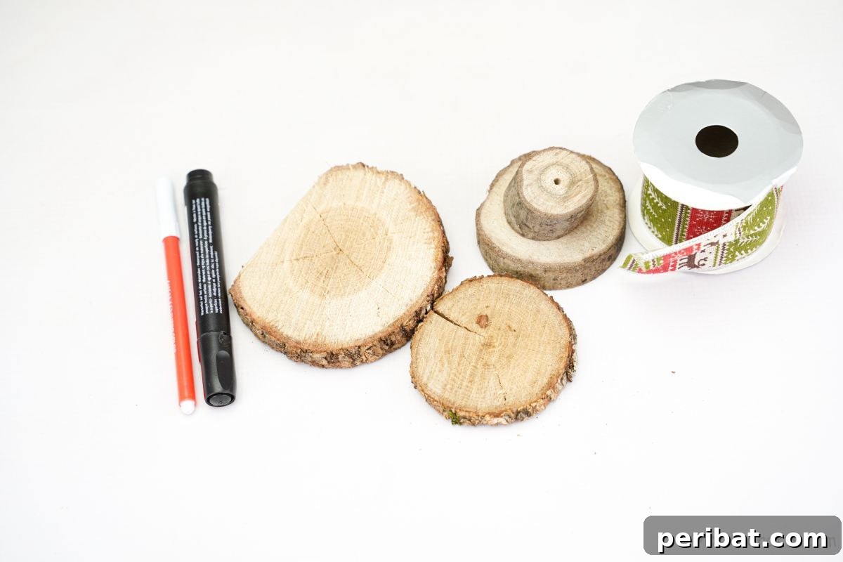Charming Wood Slice Snowman Winter Display 8 Assortment of craft supplies including wood slices, green holiday ribbon, and black and orange markers laid out on a clean white surface, ready for crafting.