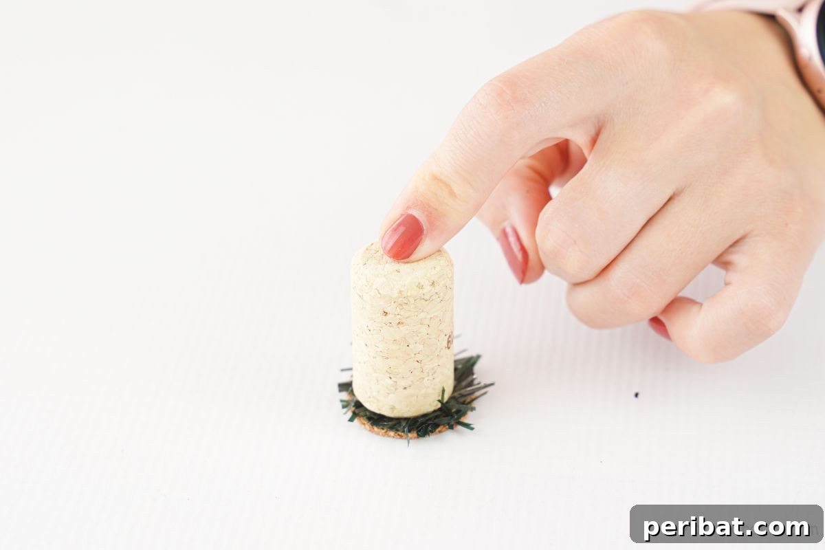 Crafted Wine Cork Candle Accents 11 finger holding down cork on greenery