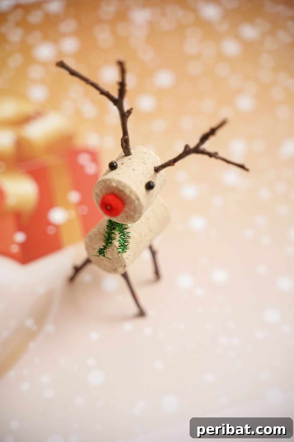 Whimsical Wine Cork Reindeer Ornament 17 A handcrafted reindeer made from wine corks sits on a piece of holiday-themed patterned paper, ready to be a festive ornament or gift embellishment.