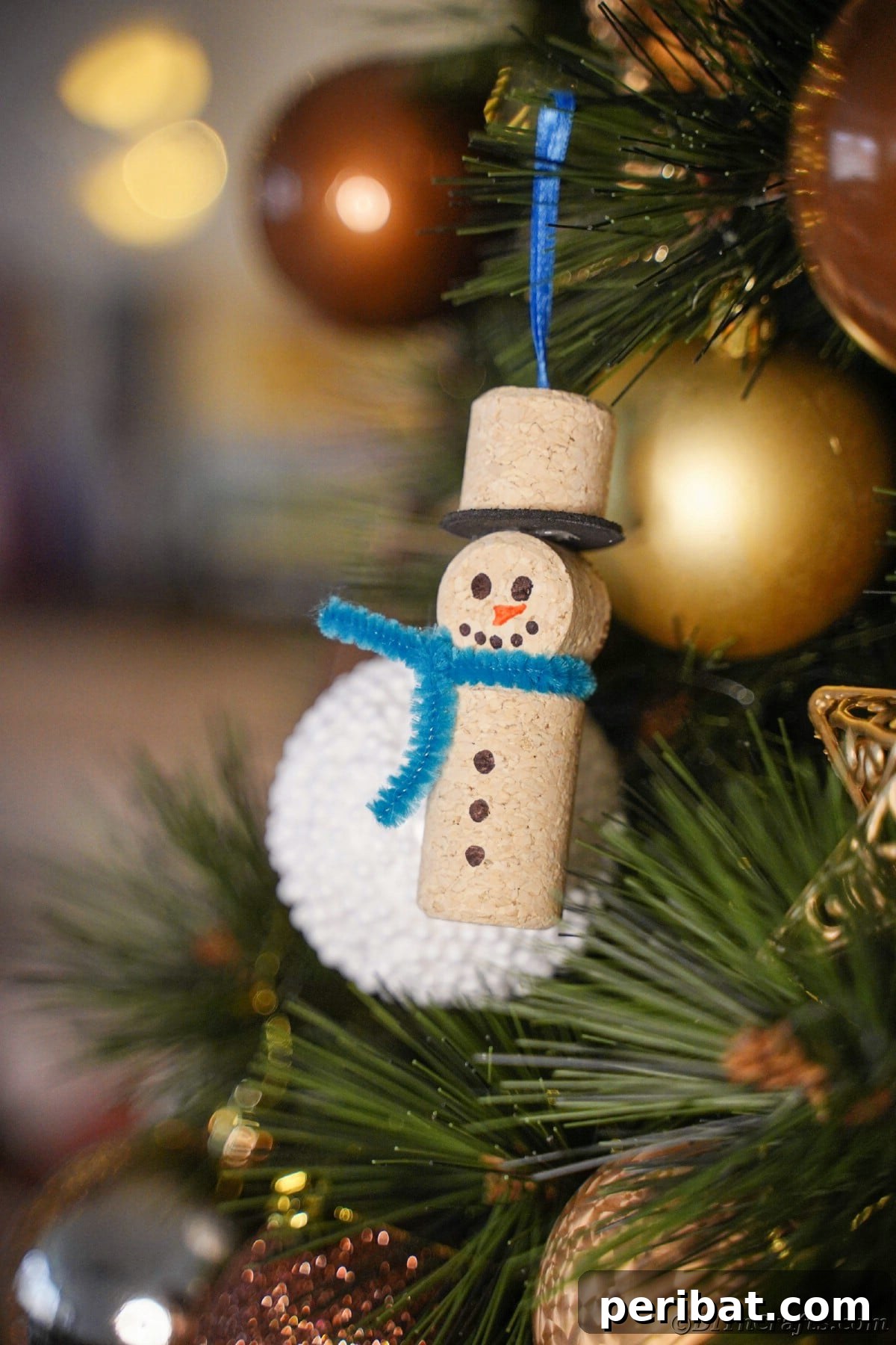 snowman ornament with blue scarf on tree