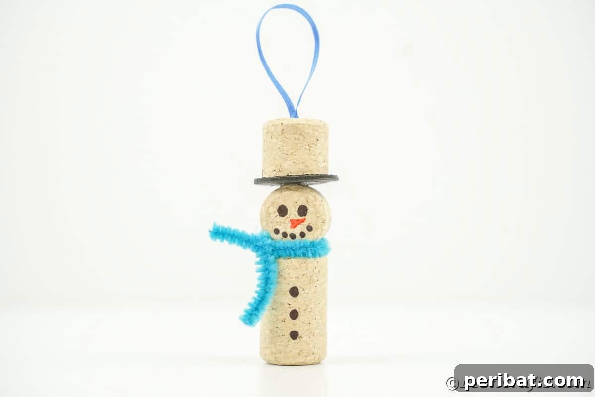 wine cork snowman with blue ribbon hanger on white table