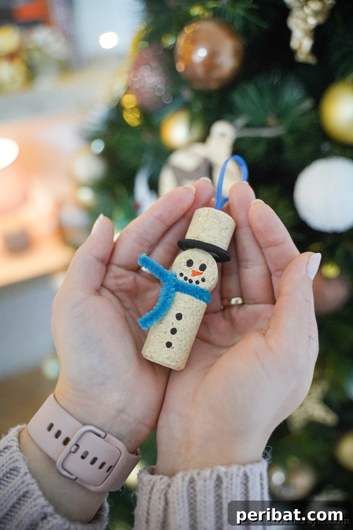 hands holding a wine cork snowman ornament