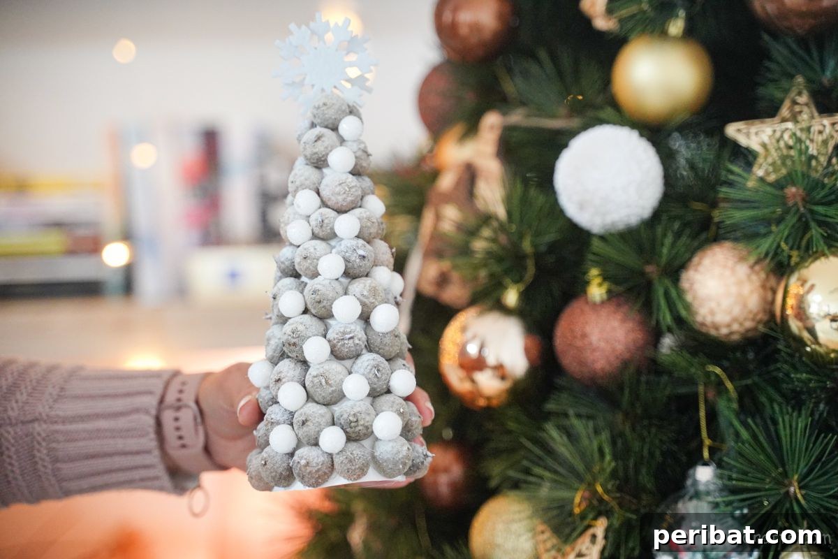 mini white acorn cap tree in front of green full sized Christmas tree