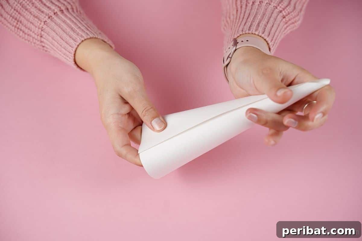 hands rolling paper into cone shape
