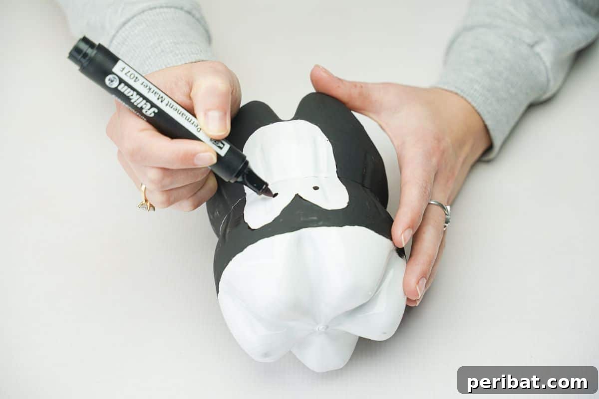 Upcycled Plastic Bottle Penguin Craft for Kids 15 black marker making eyes on penguin
