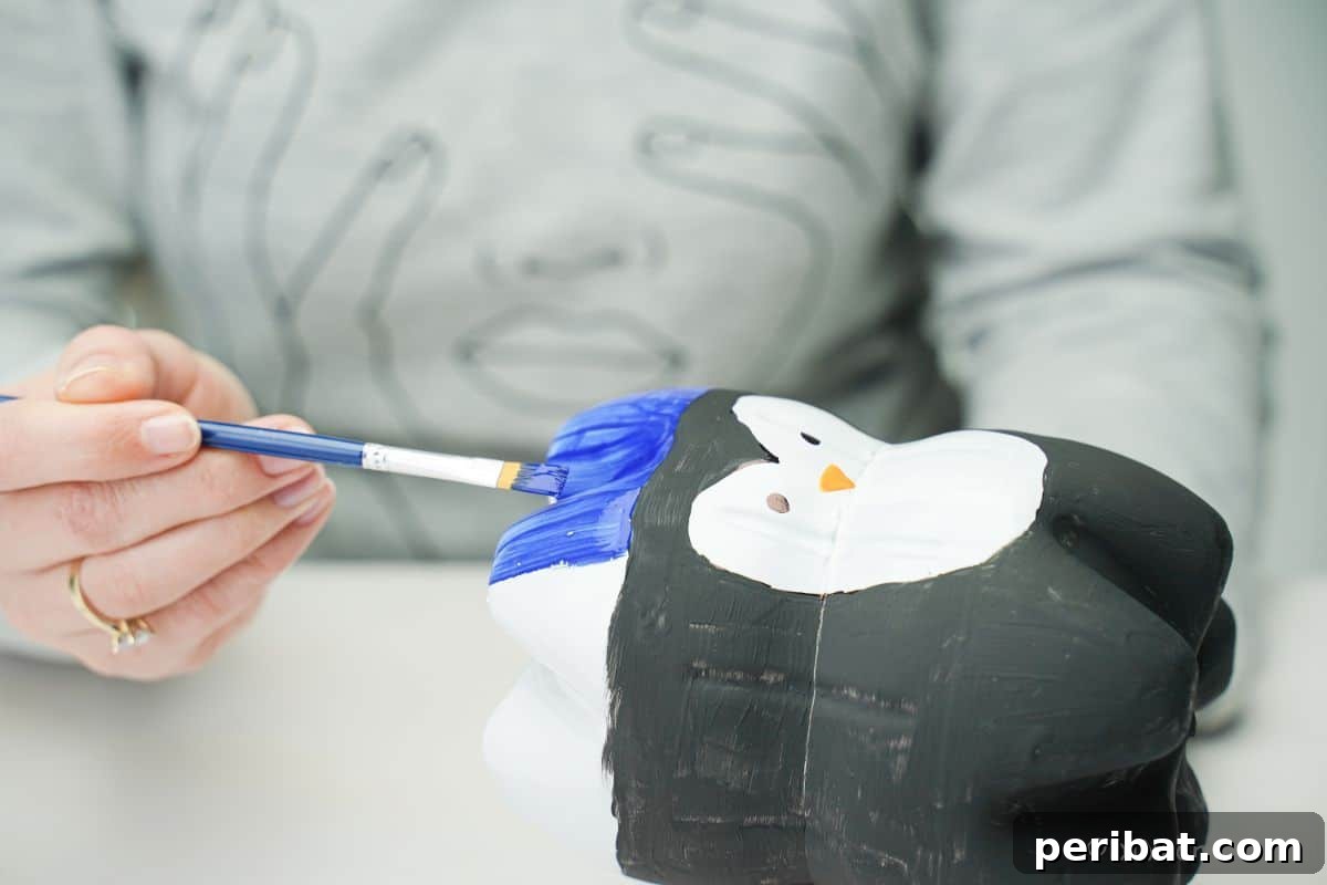 Upcycled Plastic Bottle Penguin Craft for Kids 17 hand painting blue on top of penguin body