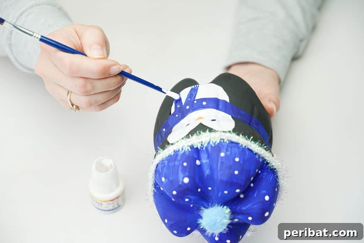 Upcycled Plastic Bottle Penguin Craft for Kids 21 hand painting white dots on blue penguin scarf