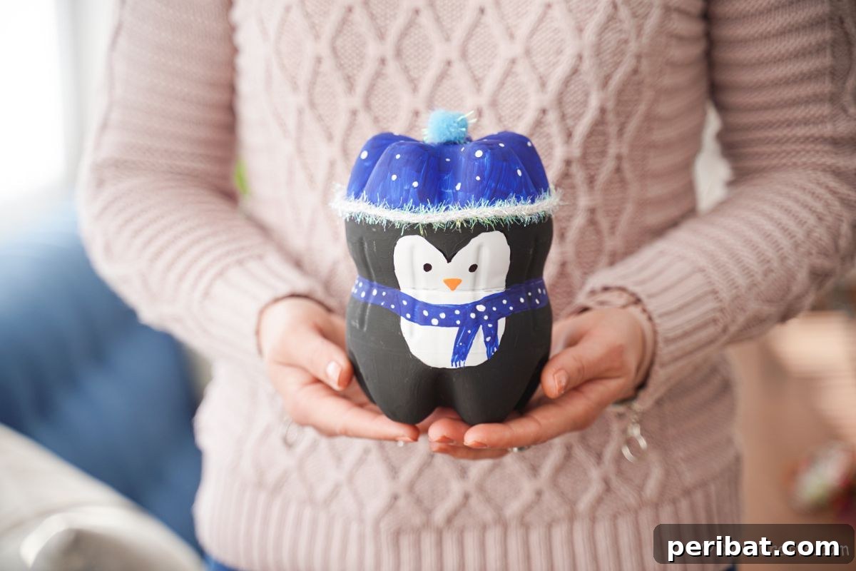 Upcycled Plastic Bottle Penguin Craft for Kids 22 lady in pink sweater holding plastic bottle penguin