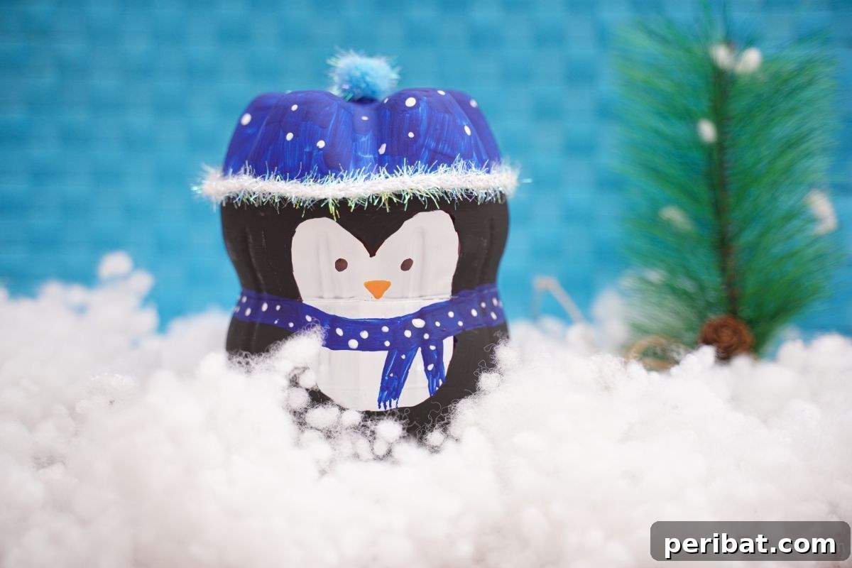Upcycled Plastic Bottle Penguin Craft for Kids 6 bottle penguin on fake snow with blue background