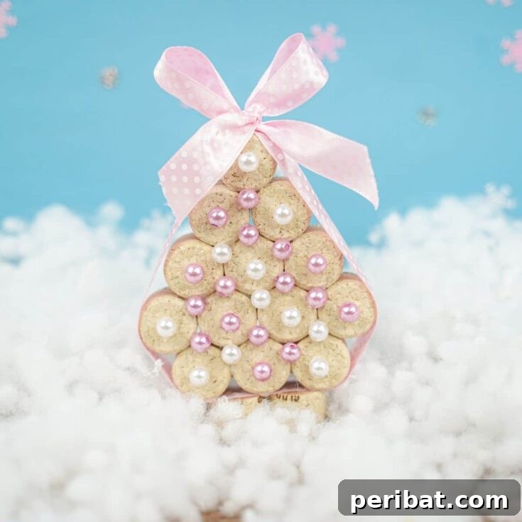 cork tree with pink ribbon and white beads on fake snow with blue background
