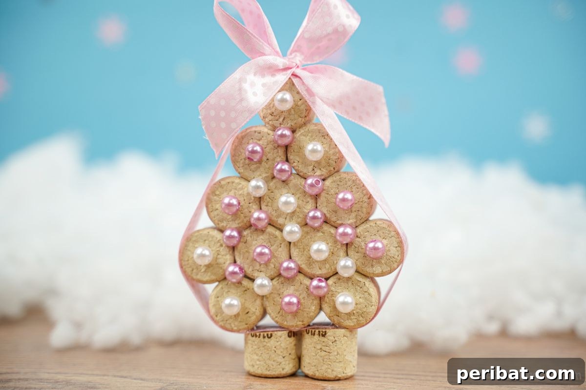 cork tree with pink ribbon and white beads on fake snow with blue background, a delightful upcycled craft