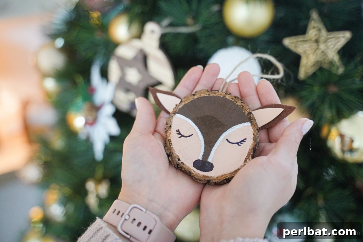 Naturally Charming Reindeer Wood Slice Decor 10 Hand holding a finished wood slice reindeer ornament with rosy cheeks