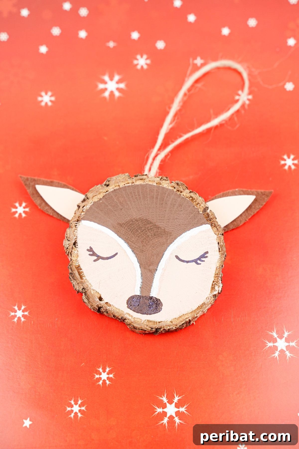 Naturally Charming Reindeer Wood Slice Decor 14 Finished wood slice reindeer ornament resting on red and white patterned paper on a table