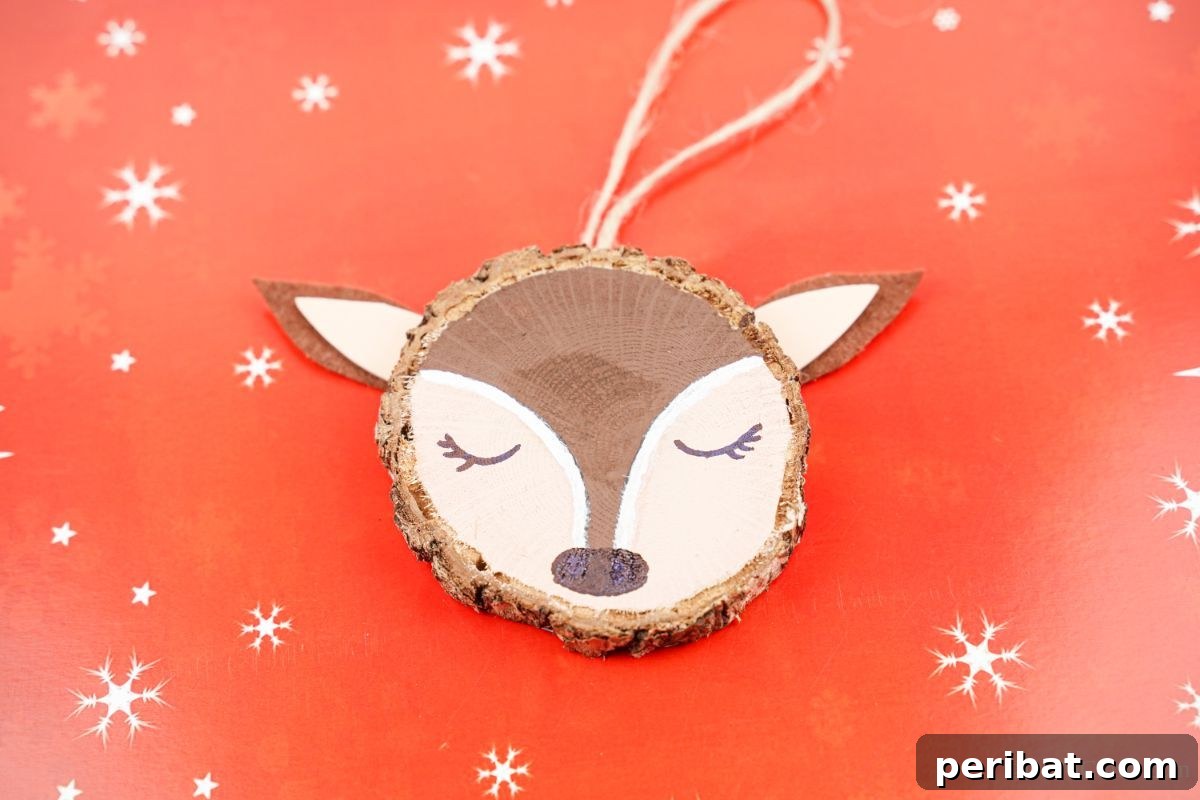 Naturally Charming Reindeer Wood Slice Decor 5 Wood slice reindeer ornament lying on red paper with snowflake patterns
