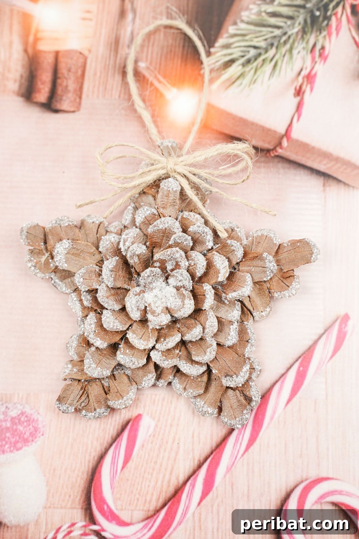 light pink holiday paper with candy cane design with pinecone star on top