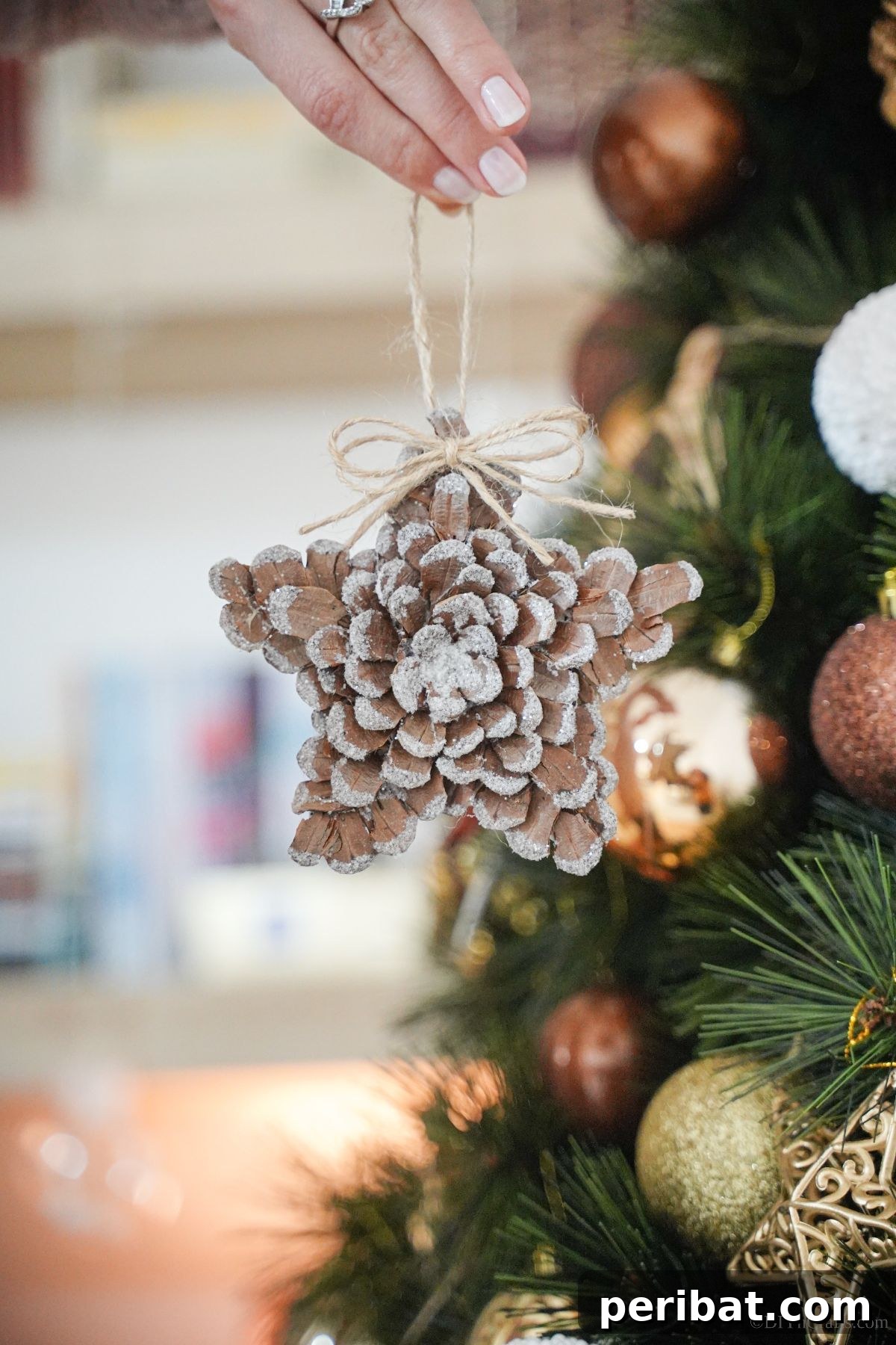 glitter star made of pinecones in front of tree