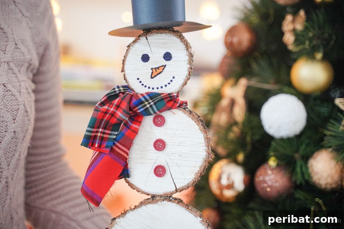 DIY Rustic Wood Slice Snowman Decor 19 A woman's hands gently holding a completed wood slice snowman, demonstrating its size and ready for display