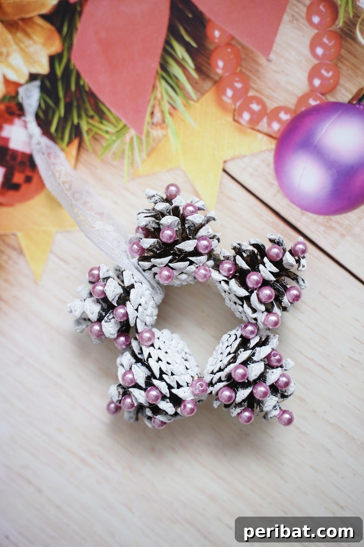 Glistening Bead-Adorned Pinecone Star 15 pinecone star ornament on cream holiday paper
